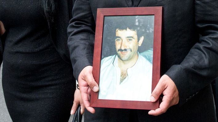 Ein Bild des Ermordeten Theodoros Boulgarides wird von seinem Bruder Gavriil Voulgaridis getragen (Bild: dpa/Tobias Hase)