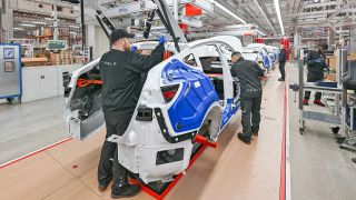 Mitarbeiter der Tesla Gigafactory Berlin Brandenburg arbeiten am 20.03.2023 an einer Fertigungslinie eines Elektrofahrzeuges vom Typ Model Y. (Quelle: dpa/Patrick Pleul)