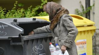 Frau sucht in einer Mülltonne in Berlin nach Pfandflaschen (Bild: imago images/Schöning)