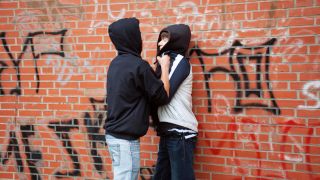 Symbolbild: Ein Teenager drückt einen Jungen gewaltsam gegen eine Wand, gestellte Szene. (Quelle: dpa/Siegfried Kuttig)