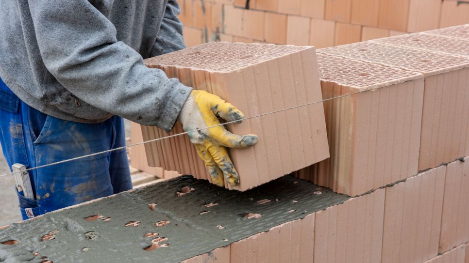 Maurer bauen eine Ziegelmauer an einem Rohbau (Bild: Colourbox/ Wolfgang Filser)