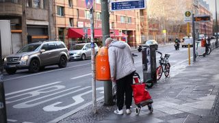 Ein Flaschensammler blickt in einen MÃ¼lleimer auf der KochstraÃe in Berlin.