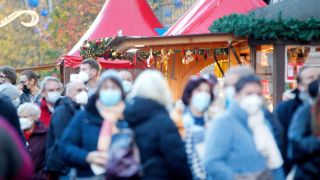 BÃ¼rger warten vor der Corona-Impfstation direkt am Weihnachtsmarkt. Vor der stationÃ¤r eingerichteten Impfstelle zwischen GlÃ¼hweinstand und WÃ¼rstchenbude bildeten sich lange Schlangen.