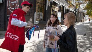 Ein Freiwilliger verteilt Informationsmaterial fÃ¼r das Referendum in Luhansk zum Beitritt Russlands