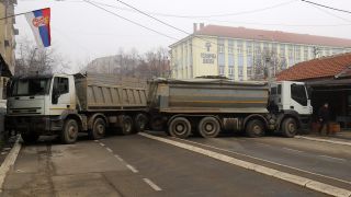 Eine StraÃenbarrikade aus mit Steinen beladenen Lastwagen