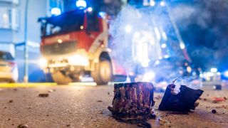 BÃ¶ller-Reste auf einer StraÃe, im Hintergrund ein Feuerwehrwagen