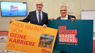 Dietmar Woidke und Klaus Freytag halten Plakate mit der Aufschrift 