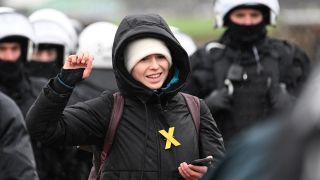 Umweltaktivistin Luisa Neubauer gestikuliert wÃ¤hrend einer Sitzblockade vor einer Reihe von Polizisten