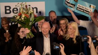 CDU-Spitzenkandidat Kai Wegner steht mit einem BlumenstrauÃ in der Hand auf der BÃ¼hne der CDU-Wahlparty.