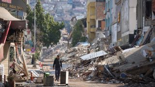 Ein Mann geht nach dem Erdbeben in der TÃ¼rkei an zerstÃ¶rten GebÃ¤uden entlang (Bild: dpa)