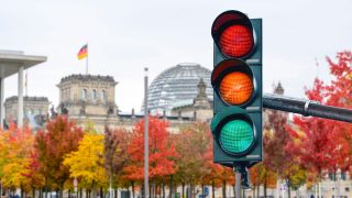 Eine Ampel, die Farben der drei Regierungsparteien zeigt, steht im Regierungsviertel Berlins. (Quelle: Picture Alliance)