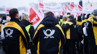 Archivbild: Das Post-Logo steht auf den Jacken der Demonstranten der Deutschen Post, die beim Warnstreik im Februar vor der ver.di-Bundeszentrale auf der SchillingbrÃ¼cke streiken.