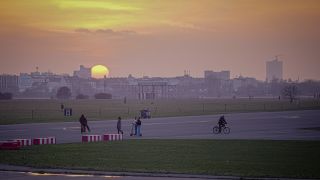 Die Sonne geht hinter dem Tempelhofer Feld unter.