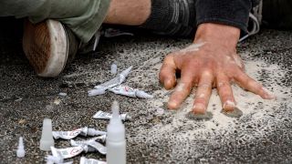 Ein Demonstrant klebt sich bei einer StraÃenblockade der Letzten Generation mit einer Hand auf die StraÃe