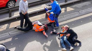 Aktivisten der Gruppe Letzte Generation blockieren die Fahrbahn auf der Autobahn A100 - aufgebrachte Verkehrsteilnehmer versuchen, sie von der StraÃe zu holen.