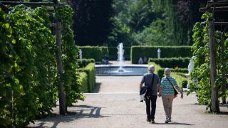 Zwei Menschen gehen durch die Parkanlage Sanssouci in Potsdam