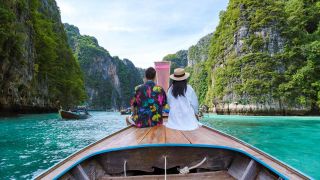 Ein PÃ¤rchen sitzt auf einem Longtail Boat in Thailand und fÃ¤hrt auf Maya Bucht der Insel Koh Phi Phi Leh ein (Bild: picture alliance / Zoonar )