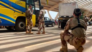 FranzÃ¶sische Soldaten stehen im Niger neben einem Bus, der franzÃ¶sische StaatsangehÃ¶rige zum Flughafen bringt.