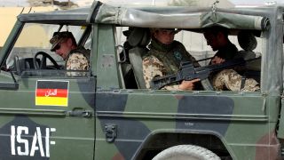 Mit dem Maschinengewehr schussbereit in der Hand fahren Bundeswehrsoldaten 2003 in einem MilitÃ¤rgelÃ¤ndewagen vom Typ 