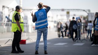 Helfer und SicherheitskrÃ¤fte stehen in der Notunterkunft fÃ¼r GeflÃ¼chtete am ehemaligen Flughafen Tegel.