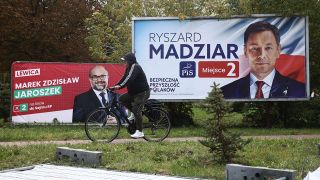 Ein Mann fÃ¤hrt mit dem Fahrrad im polnischen Chelm an Wahlplakaten vorbei. 