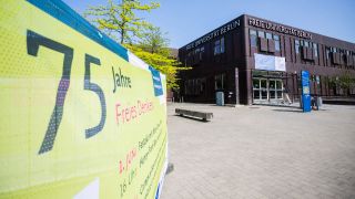 Ein JubilÃ¤umsbanner vor einem GebÃ¤udekomplex der Freie UniversitÃ¤t (FU) Berlin