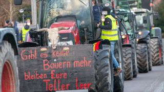 Landwirte nehmen mit ihren Treckern an einer Kundgebund Teil, auf einem Plakat steht 