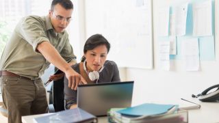 Zwei Menschen arbeiten zusammen an einem Laptop. Die Frau hat KopfhÃ¶rer um den Hals hÃ¤ngen (Bild: picture alliance / Bildagentur-online/Tetra Images) 