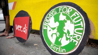 Aktivisten von Fridays for Future unterstÃ¼tzen vor dem BVG Betriebshof CicerostraÃe die Streikenden mit Plakaten und einem gelben Bus aus Pappe, auf den selbstgemalte Logos von Verdi und Fridays For Future geklebt. 