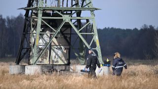 Die Polizei ermittelt an einem beschÃ¤digten Strommasten auf einem Feld in der NÃ¤he der Tesla-Autofabrik in GrÃ¼nheide (Bild: picture alliance/dpa/Sebastian Gollnow)