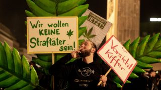 Ein Mann zieht bei einer Versammlung anlÃ¤sslich der Legalisierung von Cannabis am Brandenburger Tor an einem Joint 