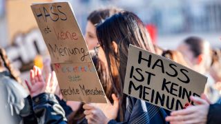 Eine Demonstrantin in Dresden hÃ¤lt ein Schild mit der Aufschrift 