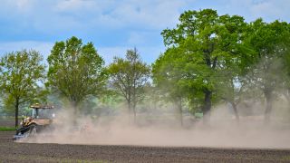 Ein Landwirt bearbeitet seinen Acker im Osten von Brandenburg mit viel Staub