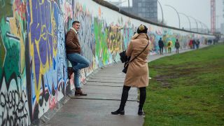 Touristen fotografieren sich mit ihren Smartphones an einem Stück der East Side Gallery, der ehemaligen Berliner Mauer.