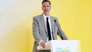 Christian DÃ¼rr (FDP) spricht bei einem Pressestatement seiner Fraktion vor einem gelben Hintergrund.