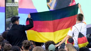 Zwei Jungen halten auf der Fanmeile am Brandenburger Tor eine Deutschland-Fahne hoch.