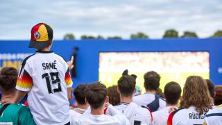 Deutsche FuÃballfans mit Flaggen und Trikot beim Public Viewing