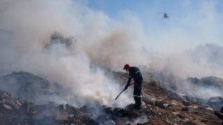 Ein Feuerwehrmann versucht, ein Feuer im Vorort Koropi im Osten von Athen zu lÃ¶schen. 