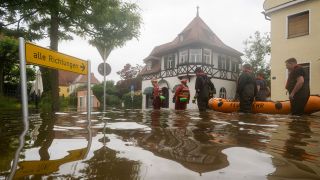 Mit einem Schlauchboot gehen Feuerwehr und Wasserrretter im bayerischen Wertingen in eine Ã¼berflÃ¼tete StraÃe (Bild: picture alliance/dpa/Stefan Puchner)