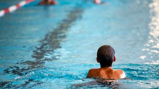 Symbolbild Hallenbad: Ein Kind schwimmt in einem Becken (Bild: picture alliance/dpa/Fabian Sommer)