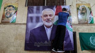 Ein PalÃ¤stinenser hÃ¤ngt ein groÃes Bild von Ismail Hanija in einer Halle im palÃ¤stinensischen FlÃ¼chtlingslager Burj al-Brajneh auf. 