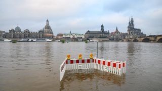 Absperrungen stehen gegenÃ¼ber der Altstadtkulisse Dresden auf den von der Elbe Ã¼berfluteten Elbwiesen.