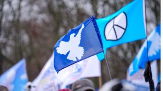 Archivbild: Demonstranten und Besucher einer Kundgebung schwenken Flaggen mit Friedenssymbolen (Bild: picture alliance / SULUPRESS.DE / Marc Vorwerk)