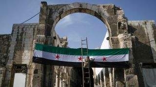 Ein Arbeiter hÃ¤ngt eine Flagge der syrischen RevolutionÃ¤re - grÃ¼n, weiÃ, schwarz mit roten Sternen am Eingang zu dem Suq al-Hamidiya, vor dem Freitagsgebet auf.