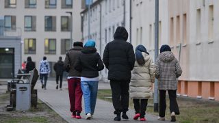 Migranten gehen Ã¼ber das GelÃ¤nde der Zentralen Erstaufnahmeeinrichtung fÃ¼r Asylbewerber (ZABH) des Landes Brandenburg in EisenhÃ¼ttenstadt. 