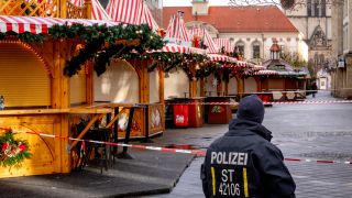 EIn Polizist bewacht den abesperrten Weihnachtsmarkt in Magdeburg (Bild: picture alliance / AP/ Michael Probst)