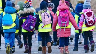 SchÃ¼ler einer ersten Klasse einer Grundschule folgen bei einem Klassenausflug an einem Januartag ihrer Lehrerin.