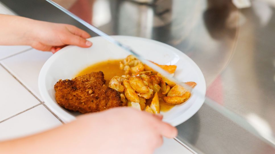 Symbolbild: Eine Grundschülerin nimmt einen Teller mit Schnitzel und Kartoffeln in einer Schulmensa (Quelle: dpa/Philipp von Ditfurth)