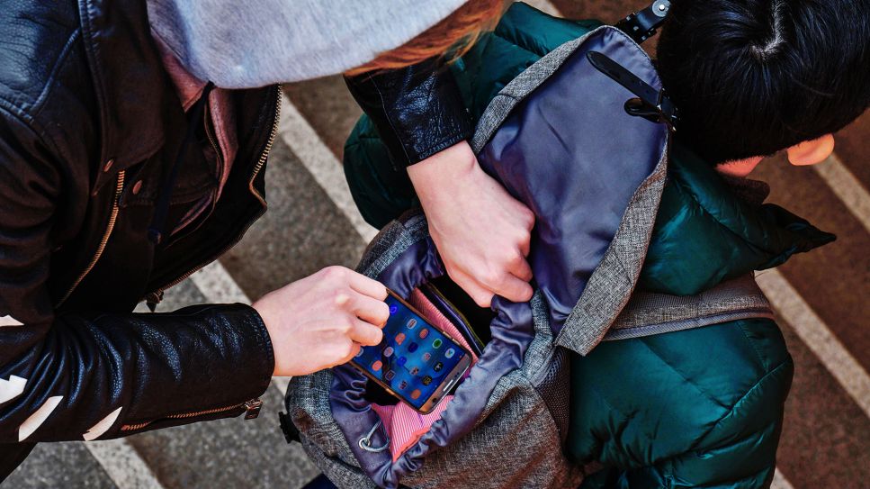 Symbolbild: Diebstahl eines Handys aus einem Rucksack, Straßenkriminalität, gestelltes Foto. (Quelle: dpa/Schoening)