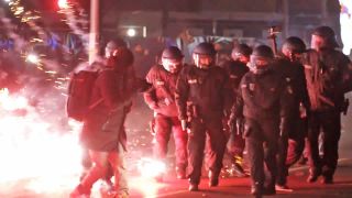 Symbolbild: Einsatzkräfte der Polizei stehen in der Silvesternacht zwischen brennendem Feuerwerk in Berlin am 01.01.2025.(Quelle: picture alliance/dpa/Julius Schreiner)